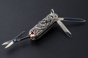 Side angle of open dragon silver multi-tool with folding tools extended