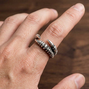 Anillo de plata de garra de águila llevado en una mano, que muestra tres garras curvas opuestas