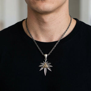 Eye of Providence Cannabis Leaf Silver Pendant, shown at the neck on an adult model; cord or chain is styling context