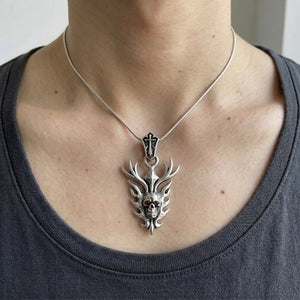Garnet Flame Skull Sterling Silver Pendant worn on a fine chain, showing the neck and collarbones