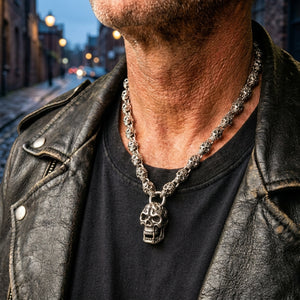 Flaming skull link sterling silver necklace worn with a black shirt and leather jacket on a blue hour city street