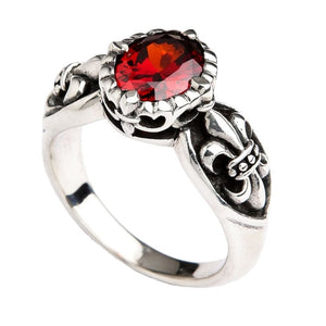 Side angle view of red stone statement ring with intricate fleur de lis scrollwork in 925 silver