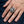Ganesha Red & Green CZ Sterling Silver Ring, worn on one middle finger in a natural hand close-up