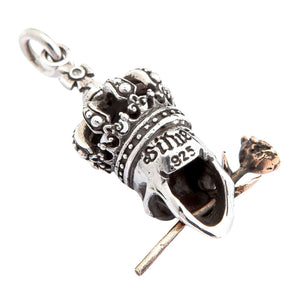 Colgante de plata con calavera coronada, ojos de granate y rosa — detalle del contraste