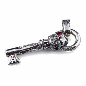 Pendentif clé tête de mort en argent sterling avec œil en grenat, clé posée horizontalement avec l'œil et la bélière visibles