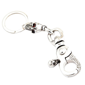Schedel sleutelhanger van .925 sterling zilver met granaatogen, achterkant op witte achtergrond
