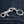 Schedel sleutelhanger van .925 sterling zilver met granaatogen, diagonaal op denim