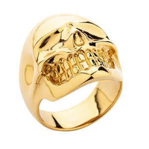 Anillo de calavera de latón bañado en oro de 14k, ángulo bajo opuesto de la calavera bañada en oro sobre fondo blanco