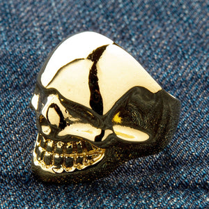 Anillo de calavera de latón bañado en oro de 14k, lado opuesto de la cara de calavera y banda curva sobre mezclilla