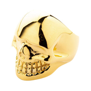 Anillo de calavera de latón bañado en oro de 14k, vista lateral de la calavera bañada en oro y banda ancha sobre fondo blanco