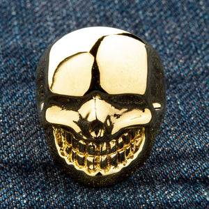 Anillo de calavera de latón bañado en oro de 14k, cara de calavera bañada en oro y dientes de frente sobre mezclilla
