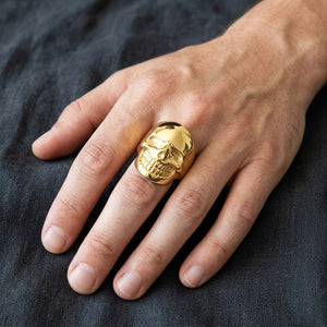 Dödskallering i mässing med 14k guldplätering buren på en hand