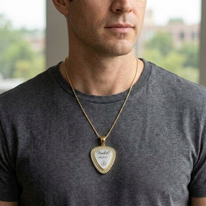 Gold-bordered guitar pick pendant with a silver center worn by a male model