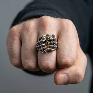 Gold skull spider silver ring worn on a hand