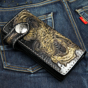 Läderplånbok med gyllene drake, stängd framsida på denim