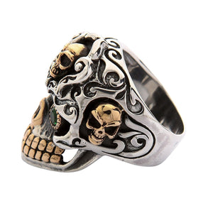 Ángulo de tres cuartos, piedras verdes en las cuencas de los ojos y calaveras más pequeñas trabajadas en la banda de plata de ley