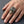 Anillo de calavera de azúcar mexicana en plata de ley 925 con ojos verdes llevado en una mano adulta