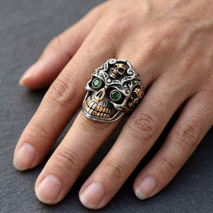 Meksikansk Sugar Skull-ring i 925 sterlingsølv med grønne øyne båret på en voksen hånd