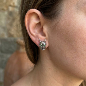 Green Eye Oni Mask Sterling Silver Stud Earrings, worn at the ear on an adult model