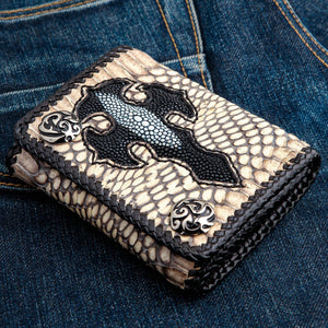 Portefeuille biker à trois volets en cobra gris et galuchat avec croix — vue en biais sur du denim