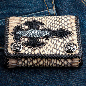 Portefeuille biker à trois volets en cobra gris et galuchat avec croix — vue de face sur du denim
