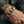 Heavy curb-link sterling silver bracelet worn on a tattooed wrist beside a black leather sleeve
