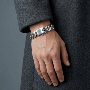 Heavy sterling silver Cuban link bracelet worn with a charcoal coat