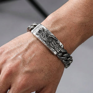 Heavy sterling silver dragon id bracelet worn on wrist for scale