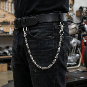 Heavy sterling silver tribal skull wallet chain attached between black jeans belt loops