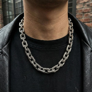 Heavyweight sterling silver dragon chain necklace worn over a black shirt with a leather jacket