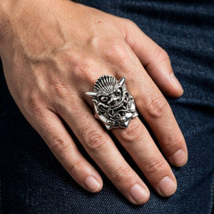 Anillo de plata con máscara de demonio japonés usado en una mano