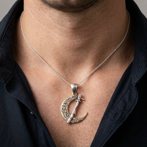 Japanese Sword & Crescent Moon Sterling Silver Pendant in a detailed front view worn at a male neckline