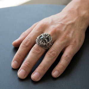 Anel de prata de lei 925 com peixes koi e ônix preto usado em uma mão adulta