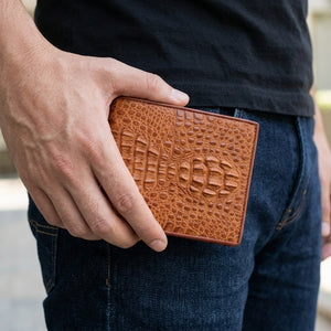 Light Brown Crocodile Hornback Bifold Wallet, held at hip level