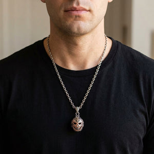 Lucha libre mask pendant worn over a black shirt; chain shown for styling