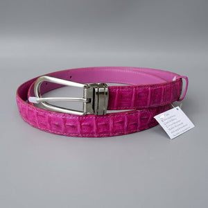 Luxury pink crocodile leather women's belt with authenticity tag on gray background