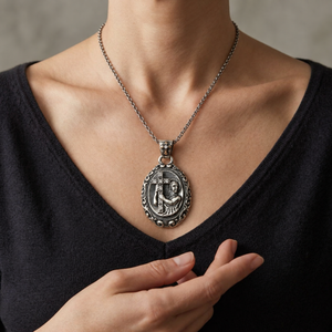 Mary and cross silver medallion pendant worn at the neckline