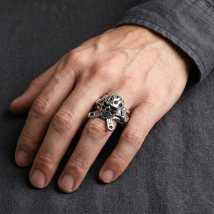 Mechanic flame skull silver ring worn on a hand, showing the ring face and band