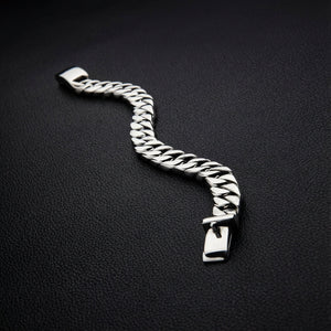Flat lay of men's sterling silver curb bracelet showing Cuban link chain pattern and craftsmanship