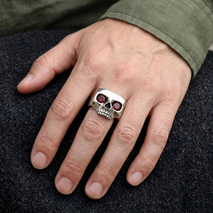 Natural Garnet Eye Sterling Silver Skull Ring worn on an adult hand.