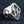 One Percent Skull Shoulder Sterling Silver Ring shown in diamond emblem oblique view.