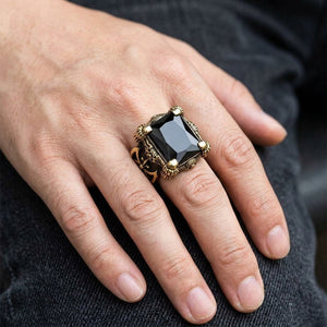 Bague en laiton à griffe de dragon et onyx noir portée à la main