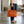 Orange Ostrich Leather Handbag carried by its handles beside the hip