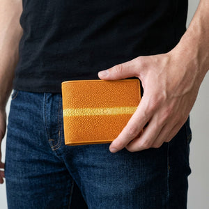 Orange Row Stingray Leather Bifold Wallet, held naturally at hip level