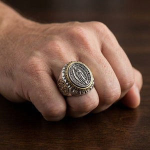 Our Lady of Guadalupe ring worn on a hand, showing the standing figure, gold-toned oval rim and brass side shield