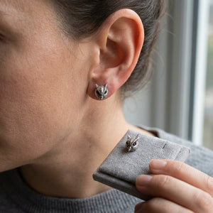 Owl Head Sterling Silver Stud Earrings worn on an adult ear