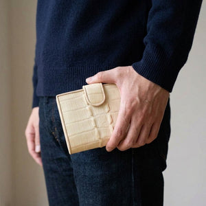 Pearl White Crocodile Tail Wallet held beside the hip