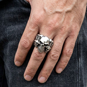 Phantom skull cluster silver ring worn on a hand, showing the ring face and band