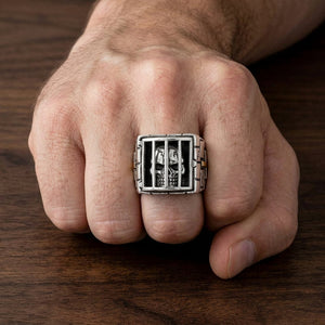 Bague tête de mort prisonnier en argent sterling avec croix d'épaulement de couleur or portée sur un poing naturellement fermé