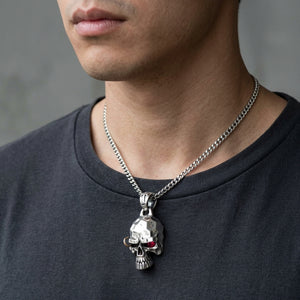 Pendentif tête de mort punk aux yeux de rubis en argent sterling 925, porté sur une chaîne en argent avec une chemise sombre